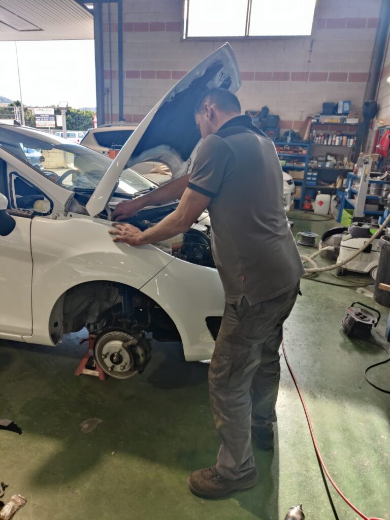 Reparación coche blanco dentro del taller